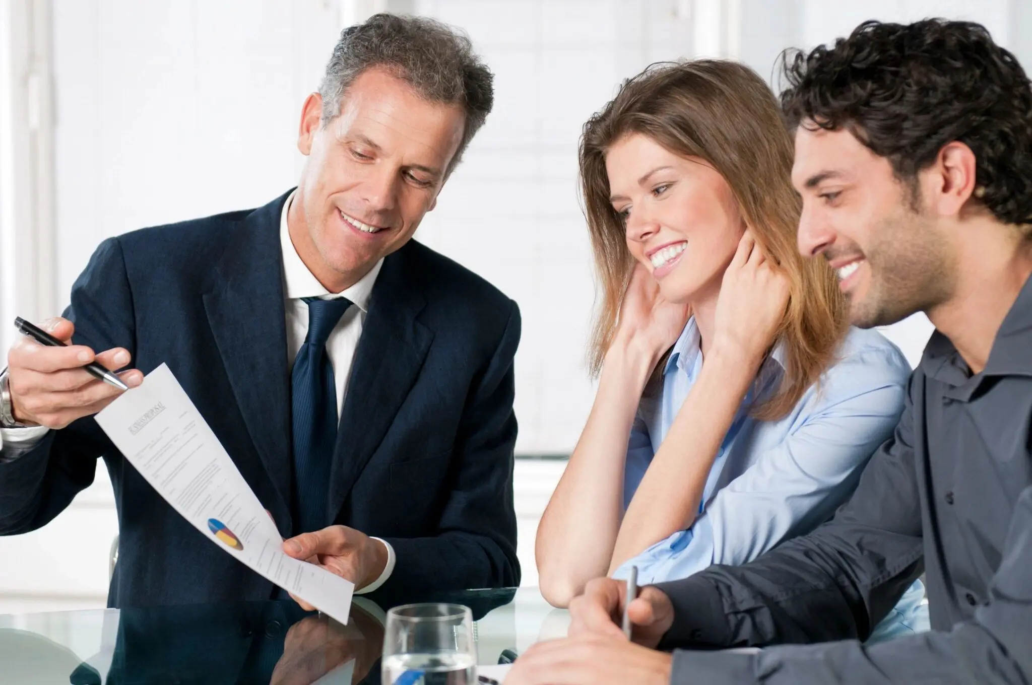 Business meeting with three people reviewing document.