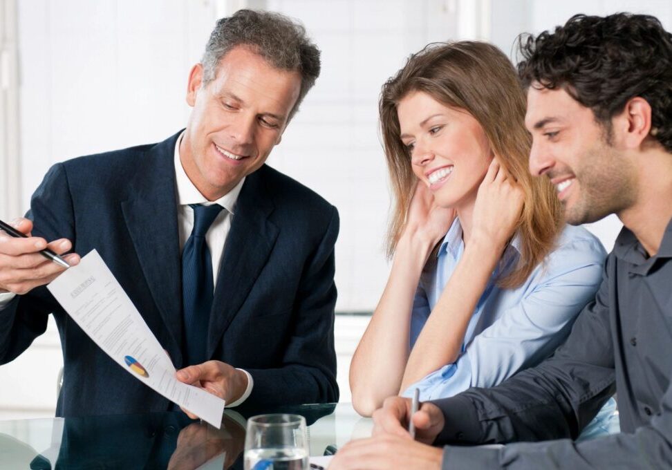Business meeting with three people reviewing document.